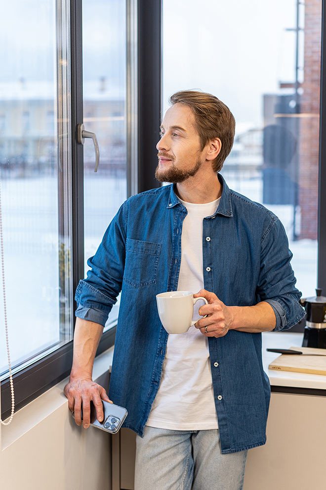 купить пластиковые окна в Воронеже Молодой мужчина у окна